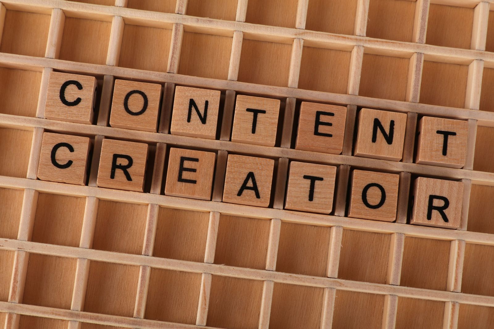 Illustrative photo of content creator block letters on a desk