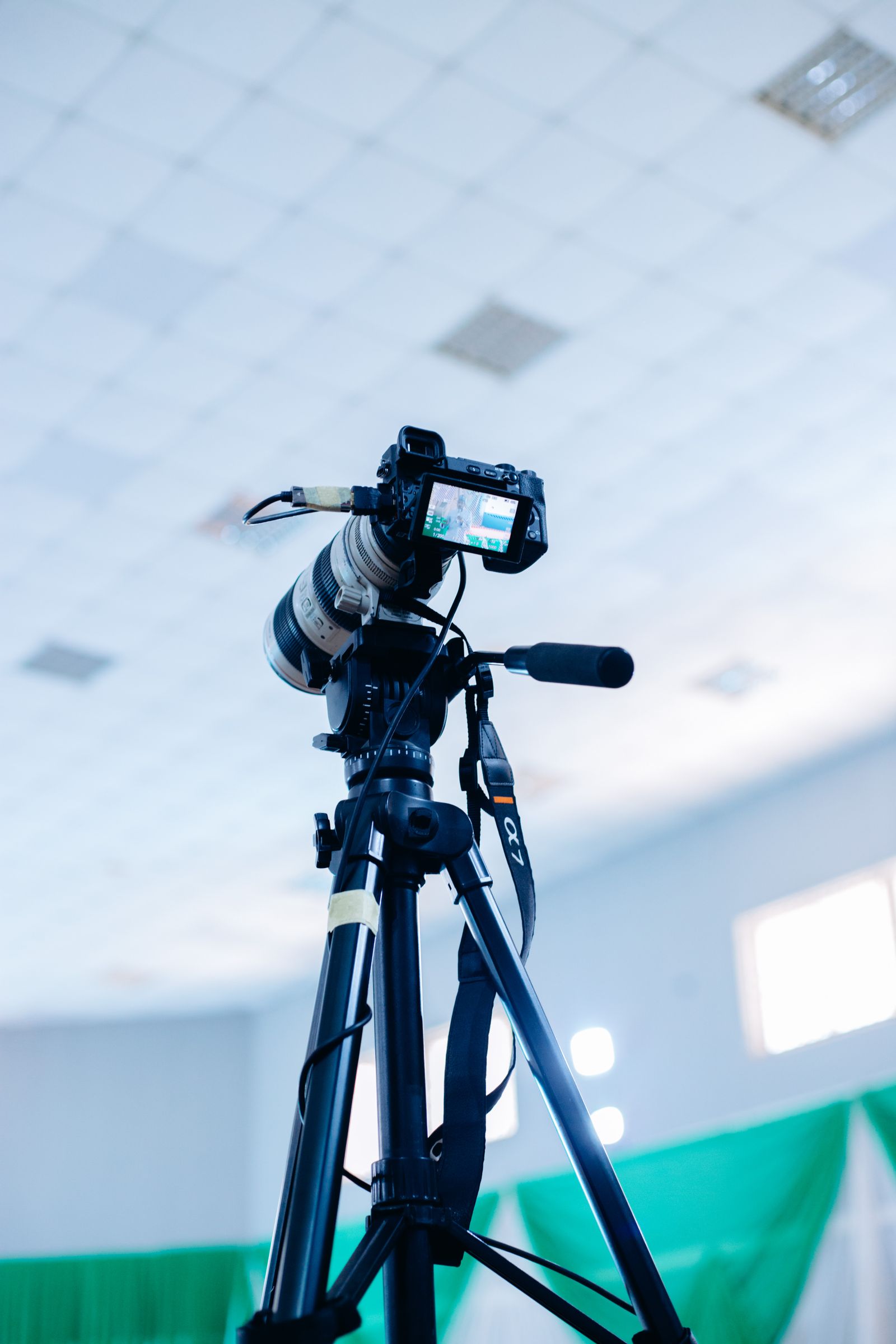 Illustrative photo of a professional camera on a tripod in a studio